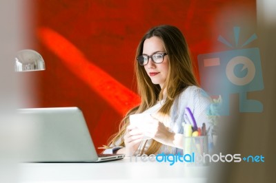 Beautiful Young Woman Working With Laptop In Her Office Stock Photo