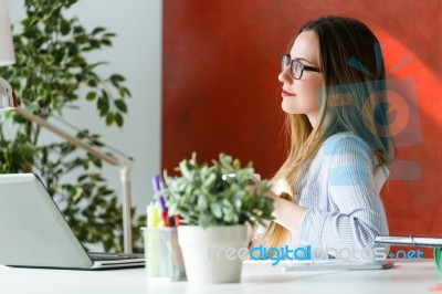 Beautiful Young Woman Working With Laptop In Her Office Stock Photo