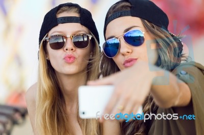 Beautiful Young Women Using Mobile Phone In The Street Stock Photo