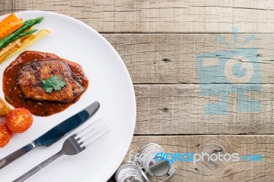 Beef Steak In Dish On Wood Table Stock Photo