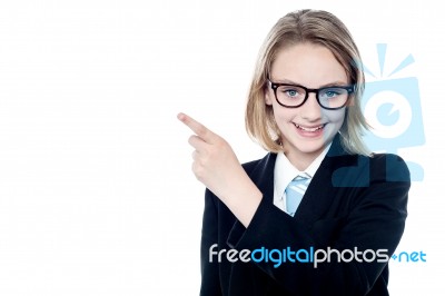 Bespectacled Business Girl Pointing Away Stock Photo