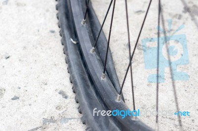 Bicycle Wheel With Flat Tyre On The Concrete Road Stock Photo