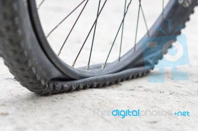 Bicycle Wheel With Flat Tyre On The Concrete Road Stock Photo