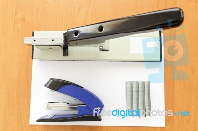 Big And Small Staplers With Staples And Paper On The Table Stock Photo