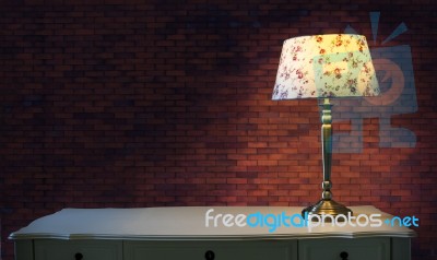 Big Brick Wall And Light Lamp On White Table Stock Photo