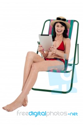 Bikini Woman Entertaining Herself Through Tablet Device Stock Photo