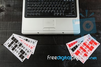 Bingo Cards And A Laptopo On Wooden Background Stock Photo