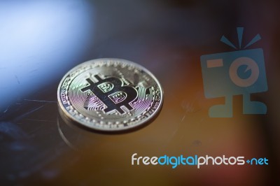 Bitcoin Curency Coin On Glass Table Stock Photo