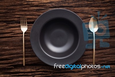 Black Bowl Plate Fork Spoon On Wooden Table Background Stock Photo