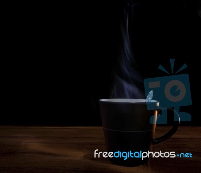 Black Cup Of Hot Coffee On Wood Texture With Dark Background Stock Photo