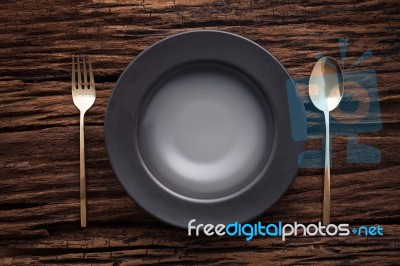 Black Empty Bowl Fork Spoon On Wooden Table Background Stock Photo