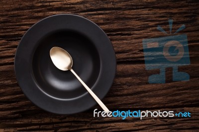 Black Empty Bowl Spoon On Wooden Table Background Stock Photo