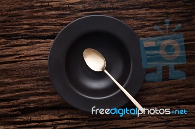 Black Empty Bowl Spoon On Wooden Table Background Stock Photo