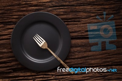 Black Empty Plate Fork On Wooden Table Background Stock Photo