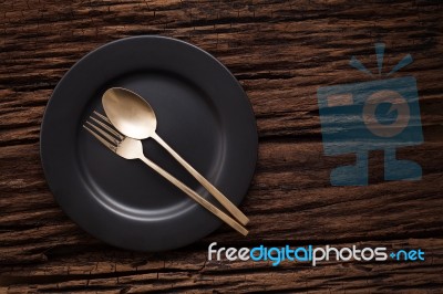 Black Empty Plate Fork Spoon On Wooden Table Background Stock Photo