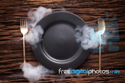 Black Empty Plate Fork Spoon On Wooden Table Background Stock Photo