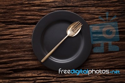 Black Empty Plate Fork Spoon On Wooden Table Background Stock Photo