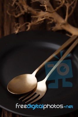 Black Empty Plate Fork Spoon On Wooden Table Background Stock Photo