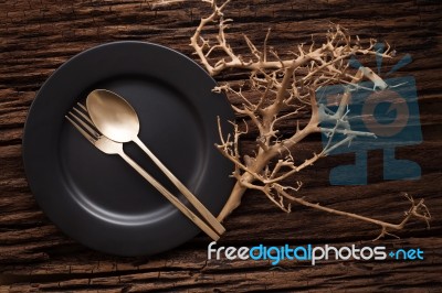 Black Empty Plate Fork Spoon On Wooden Table Background Stock Photo