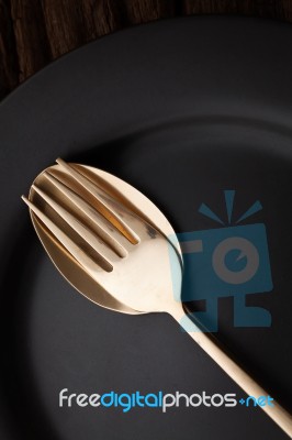 Black Empty Plate Fork Spoon On Wooden Table Background Stock Photo