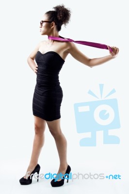 Black Woman In Evening Dress Playing With A Tie. Concept Of Domination And Authority Stock Photo