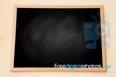 Blank Black Chalkboard With Wooden Frame On Wood Background Stock Photo