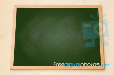 Blank Green Chalkboard With Wooden Frame On Wood Background Stock Photo