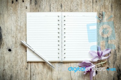 Blank Notebook With Orchids Purple Flowers On Wooden Table Stock Photo