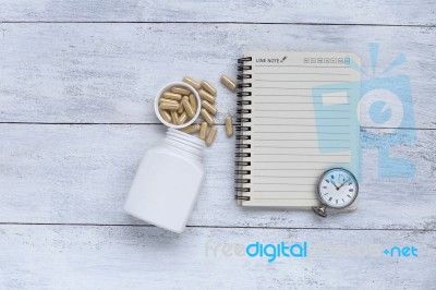 Blank Notebook With White Capsule Container With Vintage Watch Stock Photo