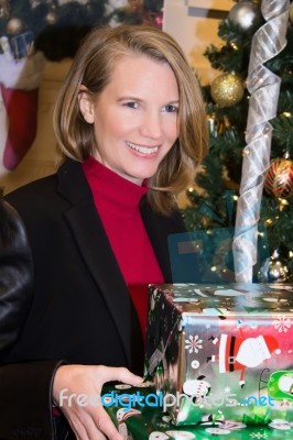 Blonde Female In Christmas Scene Holding Gifts Stock Photo