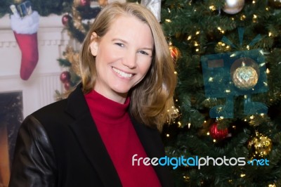 Blonde Female In Holiday Scene With Christmas Tree Stock Photo