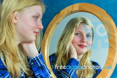 Blonde Girl Looking In Mirror Stock Photo