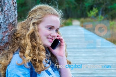 Blonde Girl Phoning Mobile In Nature Stock Photo