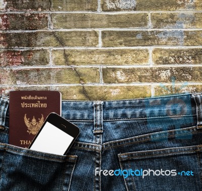 Blue Jeans With Cell Phone And Passport In A Pocket Background Stock Photo