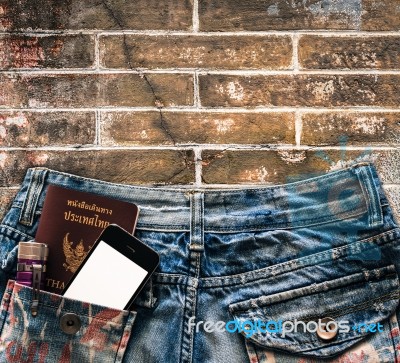 Blue Jeans With Cell Phone, Flashlight And Passport In A Pocket Stock Photo