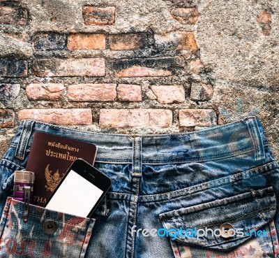 Blue Jeans With Cell Phone, Flashlight And Passport In A Pocket Stock Photo