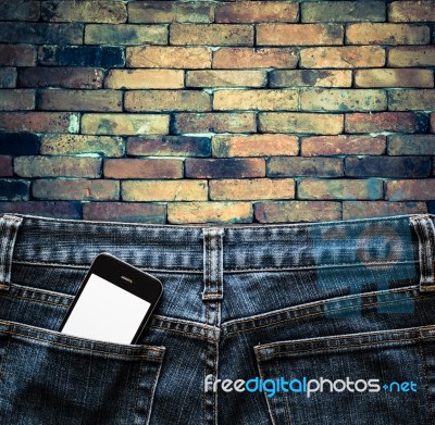 Blue Jeans With Cell Phone In A Pocket Background Stock Photo