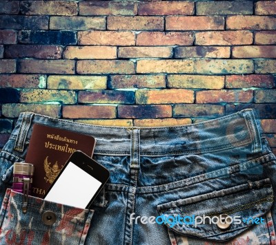 Blue Jeans With Cell Phone, Passport And Flashlight In A Pocket Stock Photo