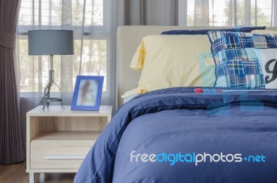 Blue Picture Frame With Modern Lamp On Wooden Side Table And Blu… Stock Photo