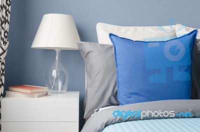 Blue Pillow On Bed With Glass Lamp On White Table In Modern Blue… Stock Photo