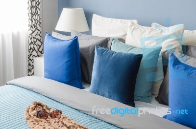 Blue Pillow On Bed With Glasses On Cloth In Modern Bedroom Stock Photo