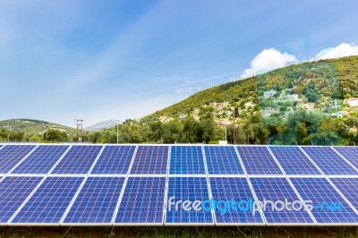 Blue Solar Collectors Near Town On Mountain Stock Photo