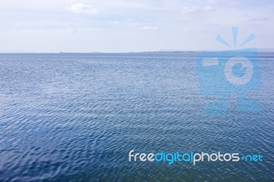 Blue Water Surface And Blue Sky Stock Photo