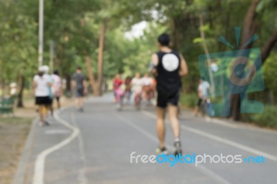 Blurred Image Of People Doing Exercise In Park Stock Photo