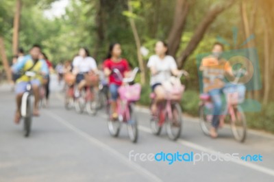 Blurred Image Of People Riding Bicycle In Park Stock Photo