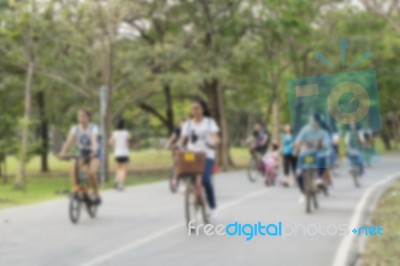 Blurred Image Of People Riding Bicycle In Park Stock Photo