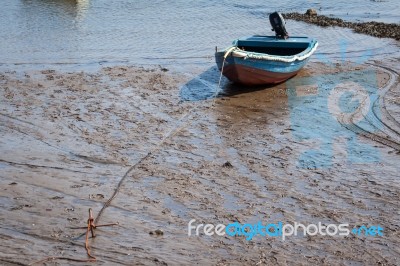 Boat Anchored On The Mud At Holy Island Stock Photo