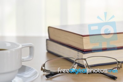 Book And Eyeglasses On A Wood Table Stock Photo