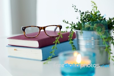 Books, Glasses And Candle On The Night Table Stock Photo