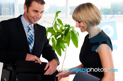 Boss Opening His Briefcase In Front Of Secretary Stock Photo